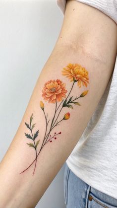 a woman's arm with orange flowers on the left side of her arm and an arrow