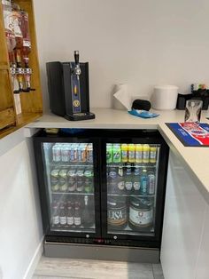 a refrigerator with drinks in it sitting next to a counter