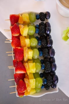 fruit skewers are arranged in the shape of a rainbow