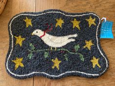 a bird hooked up to a door mat with stars on the floor next to it