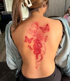 a woman with a red tattoo on her back