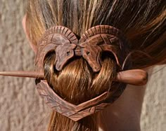 a woman with long hair has two elephants in the shape of a heart on her head