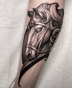 a black and white horse head tattoo on the arm