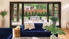 a living room with blue couches and large windows looking out onto the patio area