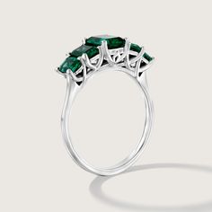 Spectacular. Stunning. Unforgettable. In our new Alexandrina ring we created a goldsmith masterpiece unlike anything else. Five large and deep-green emeralds are elevated above the ring with an elegant bridge decorated with our signature sign, forming an architectural perfection on your finger. It's not just a bling, the skilled craftsmanship and unique design turn the Alexandrina ring into a true heirloom that will never go out of style and will be passed through generations. **Due to the natur Timeless Green Emerald Ring With Center Stone, Formal Emerald Rings Fine Jewelry, Luxury Emerald Cluster Ring For Promise, Luxury Emerald Cluster Promise Ring, Emerald Cut Green Gemstone Cluster Ring, Luxury Emerald Birthstone Ring For May, Timeless Emerald Cut Sterling Silver Emerald Ring, Emerald Ring With Baguette Cut For Formal Events, Emerald Cluster Ring With Brilliant Cut