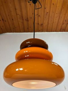 an orange and brown lamp hanging from a ceiling