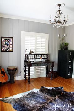 a living room filled with furniture and a chandelier hanging from the ceiling over a wooden floor