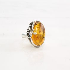 This ring is a size 8 (USA); It may be resized. Markings: 925 GT (Tested & guaranteed to be Sterling Silver) This ring weighs 8 Grams The Stone/Design is Orange Amber Oval, Swirl    Natural, heated  The Stone/Design measures 22.4 x 13.5 mm The Ring face measures 25.5 x 18.9 mm The condition of this ring is Estate, Very good, some patina  This vintage item is circa 1990  To have us do the resize, add this listing and the resize listing to your cart and select which size you would like this ring t Nickel-free Oval Wedding Rings, Adjustable Oval Amber Ring, Amber Sterling Silver Oval Cabochon Ring, Amber Sterling Silver Ring With Oval Cabochon, Classic Amber Oval Cabochon Ring, Amber Oval Cabochon Sterling Silver Ring, Oval Amber Hallmarked Rings, Minimalist Silver Ring, The Ring Face