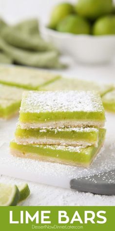 lime bars with powdered sugar on top and sliced limes in the back ground