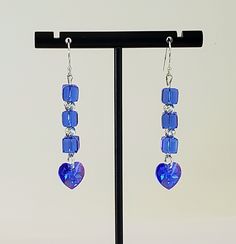 - Stunning Swarovski Faceted Sapphire Blue Crystal Dangle Earrings in 6mm Cubes and 14mm Xilion Hearts AB. See Photos #1-2. - Crystal AB stands for Aurora Borealis referring to picking up colors around it. - 925 Sterling Silver 4mm Corrugated Beads and 3mm Pyramid Beads accent. - Nice swing to these 2 1/4" Length Earrings. - 925 Sterling Silver Filled Bali Hook Ear Wires with Ball Ends.  - 925 Sterling Silver Filled Lever Backs Listed separately. See Photo #4. - 925 Sterling Silver Posts/Studs with 4mm Ball Ends and Backs upon request at no added cost. Give us a Note on Etsy at Checkout with any change request. - Photos of other "Blues" from our Jewelry Collections included for reference. Each is separately Listed. - All our Products arrive in a beautiful Gift Box with Bow.  - What a gorge Blue Sterling Silver Heart Dangle Earrings, Blue Jewelry With Matching Earrings For Valentine's Day, Blue Hypoallergenic Heart-shaped Earrings, Blue Nickel-free Sterling Silver Heart Earrings, Blue Sterling Silver Nickel-free Heart Earrings, Blue Heart Beads Jewelry For Anniversary, Blue Heart Cut Jewelry For Jewelry Making, Handmade Blue Heart Cut Jewelry, Blue Dangle Heart Earrings With Heart Beads