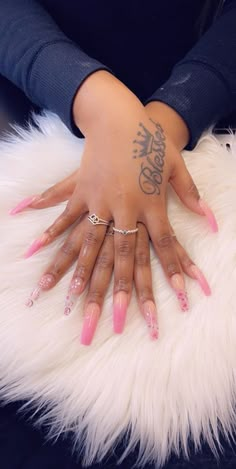 a woman's hands with pink and white nail polishes on her left hand