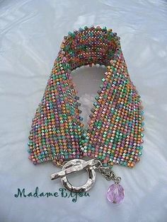 multicolored beaded bracelet with metal clasp and keychain on white background