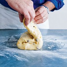 a man is kneading dough on top of a blue tablecloth and preparing to bake