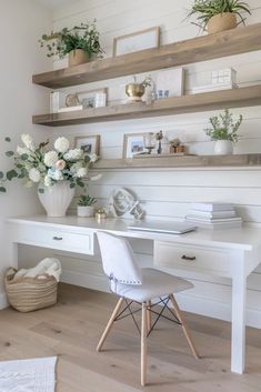 a white desk topped with lots of shelves filled with plants and flowers on top of it