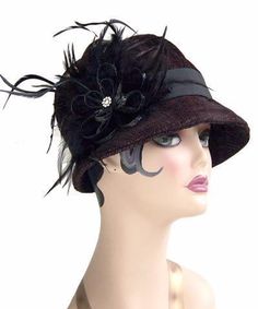 THE GRACE, handmade in Seattle, WA, USA, is a soft and flexible, 1920s style cloche hat. This hat is shown in Bongo Black/Gray Upholstery Fabric with assorted bands and trims. The brim is 2" at center front, flaring out to 2 3/4" at side front, and curving back to 3/4" at center back of hat. The crown is made of six panels. Prices are as shown. May be ordered without band for $79. These hats are custom made and all sales are final. Available in Medium 22-1/2 " and Large 23-1/2 " with custom sizi Elegant Black Bucket Hat, Gatsby Style Adjustable Cloche Hat With Curved Brim, Adjustable Gatsby Top Hat With Short Brim, Adjustable Gatsby Cloche Hat With Curved Brim, Elegant Black Bucket Hat With Short Brim, Fitted Flapper Cloche Hat, Fitted Flapper Cloche Hat With Brim, Adjustable Wide Brim Flapper Hat, Adjustable Cloche Hat In Flapper Style