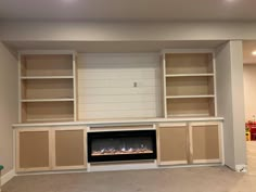 an empty living room with built in fireplace