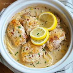 a white bowl filled with chicken and lemons