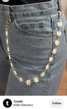 the back of a woman's jeans with flowers attached to her waist and chain