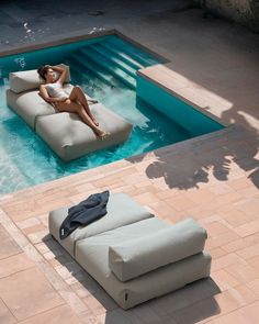 a woman lounging on an inflatable lounge chair next to a swimming pool