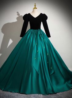 Drenched in elegance and striking contrast, this Quinceanera dress is designed for the modern princess! The rich black velvet bodice stands out beautifully against the deep emerald green satin skirt, creating a visually stunning effect. The puffed long sleeves evoke a sense of timelessness, offering a regal look thatperfect for the grand occasion. The carefully placed floral details on the skirt add just enough sparkle, elevating the gown with a touch of glamour. This dress is ideal for the Quinceanera who wants a gown that combines classic beauty with contemporary flair. The full skirt provides dramatic movement, making every turn on the dance floor a moment to remember. Whether you're posing for pictures or entering your party, this gown will make you feel like royalty. Royal Dresses Princesses Gowns, Royal Dresses Princesses, Long Sleeve Quinceanera Dresses, Goddess Of Time, Green Satin Skirt, Quinceanera Dresses Green, Posing For Pictures, Haute Couture Wedding Dress, Deep Emerald Green