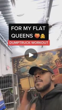 a man in a black hoodie is standing next to a sign that says for my flat queens dumptruck workout