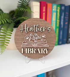 a wooden sign that says heather's library on top of a book shelf