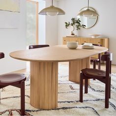 a dining table with chairs around it and a vase on the table next to it