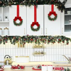 christmas wreaths are hung above the kitchen counter