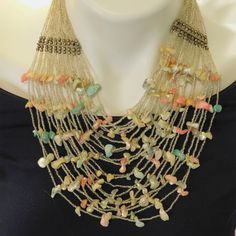 Twenty strands of beautiful glistening silvery seed beads and pastel shell piece. The result is a light, summery bohemian look making a big statement. This lovely vintage bib necklace is unmarked and has a hook closure. It presents in very good condition - there is a small metal bead by the connector bar missing. It doesn't case any issues and is not easily noticeable. The wearable length is 17 inches long and it measures about 5-6 inches at the widest part. Bohemian Silver Beads Jewelry For Summer, Bohemian Jewelry With Silver Beads For Summer, Bohemian Silver Beaded Jewelry For Summer, Bohemian Necklaces With Silver Beads For Beach, Bohemian Beach Necklace With Silver Beads, Bohemian Necklace With Silver Beads For Beach, Bohemian Silver Beads Jewelry For Beach, Bohemian Multi-strand Beige Jewelry, Handmade Silver Beaded Necklaces For Summer