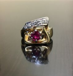 DeKara Designs Classic Beautiful Art Deco Ruby and Diamond Ring Handmade. Metal- 14K Yellow Gold, .583 Stones- 1 Natural Round Ruby 0.85 carats, 6 Round Diamonds, G-H Color SI1-SI2 Clarity .32 carats. Art Deco Inspired 14K Yellow Gold Ruby Diamond Engagement Ring. There is a beautiful six prong set round ruby that is set in a 14K White Gold setting to bring out the color of the ruby. The bottom of the the ring (or the top depending which side you wear the ring) has six round pave set diamonds. T Heirloom Yellow Gold Ruby Ring With Accent Stones, Heirloom Ruby Ring With Accent Stones In Yellow Gold, Unique Yellow Gold Ruby Promise Ring, Anniversary Yellow Gold Wedding Ring With Accent Stones, Wedding Ruby Ring In Yellow Gold With Accent Stones, Heirloom Ruby Ring With Diamond Cut In 14k Gold, Heirloom 14k Gold Ruby Ring With Diamond Cut, Heirloom Style Ruby Ring With Brilliant Cut For Anniversary, Heirloom Ruby Ring With Brilliant Cut For Anniversary