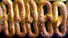 several large pretzels with sesame seeds on them are lined up and ready to be eaten