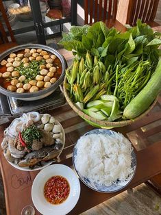 a table topped with plates and bowls filled with food next to other foods on top of a wooden table