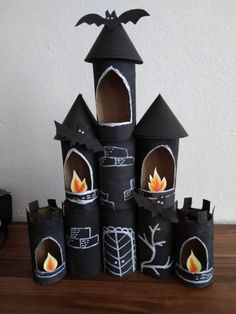 some sort of castle made out of toilet paper with fire in the middle and bats on top