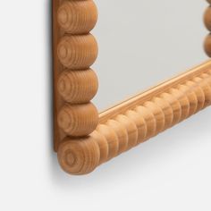 a wooden frame mirror hanging on the wall