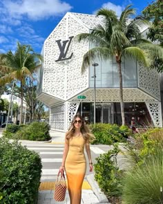 a woman in a yellow dress is walking down the sidewalk