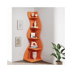 an orange curved shelf in the corner of a white room with a potted plant