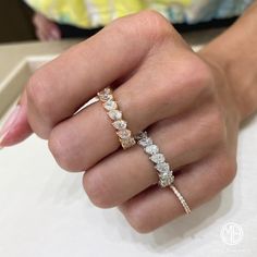 a woman's hand holding an engagement ring with three stones on it and the other side