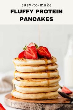 a stack of pancakes with strawberries on top and syrup drizzled over them