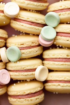 macaroons with pastel pink, green and white frosting are arranged in rows