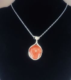 23mm x 21mm fossil coral oval cabochon wrapped in sterling silver on an 18 inch sterling silver 2.1mm double rope chain.  Fossil coral is a beautiful stone and according to metaphysical beliefs, fossil coral is a grounding stone good for bringing about change. Silver Carnelian Round Pendant Jewelry, Silver Sunstone Jewelry For Gift, Silver Sunstone Jewelry As A Gift, Sterling Silver Hand Wrapped Necklace, Hand Wrapped Sterling Silver Round Necklace, Silver Sunstone Jewelry With Natural Stones, Hand Wrapped Sterling Silver Necklace, Sterling Silver Rope Chain Jewelry Gift, Silver Carnelian Oval Cabochon Jewelry