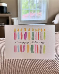 a birthday card with watercolor candles on it