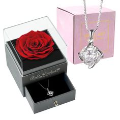 a red rose in a box and a necklace with a diamond on the inside is shown