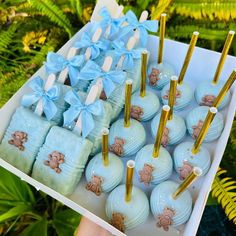 a box filled with blue and gold baby shower balls covered in fondant teddy bears