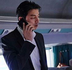 a man in a suit talking on a cell phone