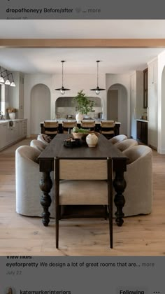 the dining room table is surrounded by beige chairs and an oval shaped bench with two vases on it