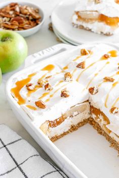 there is a dessert in the pan on the table with apples and nuts around it