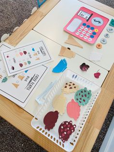 a wooden table topped with lots of different types of paper cut outs on top of it