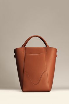 Experience modern simplicity with the Marina Bucket, embodying the dynamic spirit of city-living. Crafted from responsibly sourced Italian top grain leather, this sleek and lightweight bag complements any outfit. It features a central compartment that accommodates up to a 14" laptop, and can be worn as a handbag or shoulder bag. Plus, includes a detachable leather zip pouch for those spontaneous moments on-the-go. Leather Work Bag, Leather Zip Pouch, Sustainable Leather, Lightweight Bag, Stylish Shoulder Bag, Leather Bucket Bag, Leather Bucket, Monogrammed Items, Work Bag