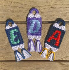 three crocheted key fobs with letters on them