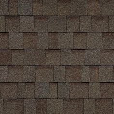 a close up view of a roof with brown shingles and dark gray tiles on it